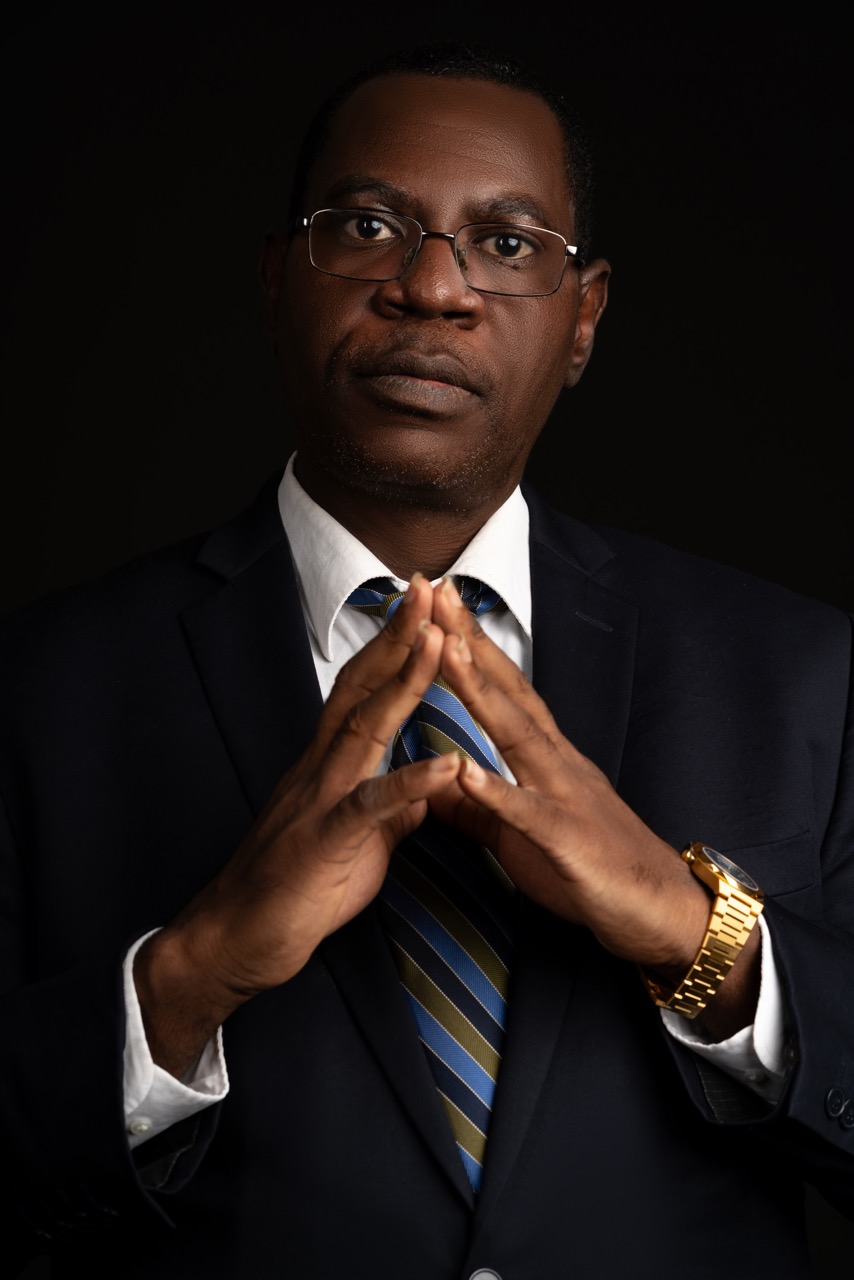 Black Business Man poses against black backdrop in navy suit and tie Headshots Mild Studios Toronto, Ontario