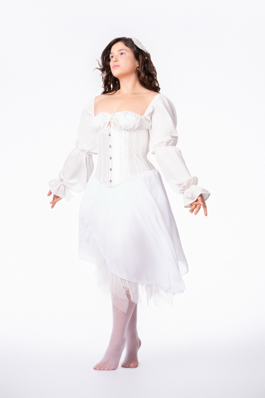 Model poses in all white dresss with flowers in her hair. Angelic Mild Studios Toronto, Ontario